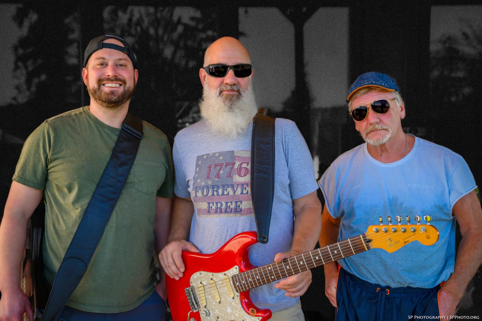 Phatt Ruby together in warm evening light against a darkened backdrop — Grant Stampfli, Carey Calhoun and Mike Lynch